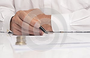 Contract signing concept. Businessman hand with pen over document closeup