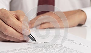 Contract signing concept. Businessman hand with pen over document closeup