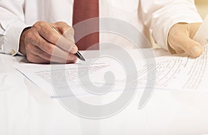 Contract signing concept. Businessman hand with pen over document with copy space available