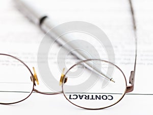 Contract and silver pen through spectacles