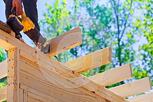 Contractor builder uses a cordless reciprocating saw to cut beam during construction