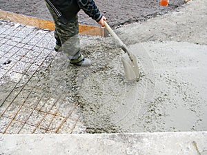 Contractor building new concrete pavement foundation in the garden. Foundation construction for paving, path