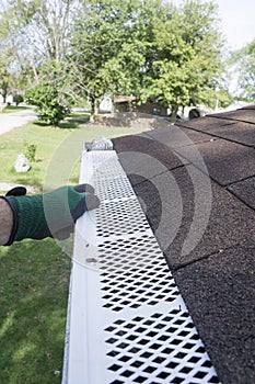 Contractor Checking Installation Of Plastic Leaf Guards photo