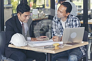 Contractor construction engineer meeting talking together on architect table at construction office site. Businessman engineer