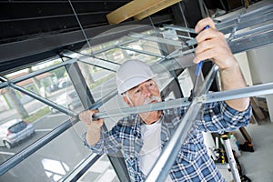 Contractor erecting framework for suspended ceiling