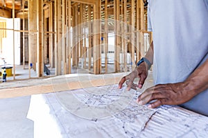 Contractor foreman reviews plans for house construction