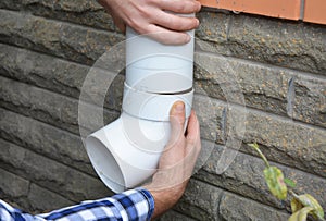 Contractor hands repair, install rain gutter downspout pipe. Guttering, Rain Chain Drainage.