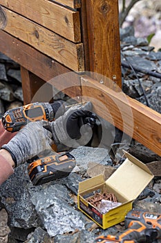 Contractor hanyman using tools to buildi a horizontal fence made from stained cedar