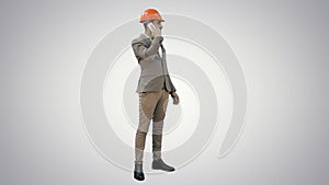 Contractor in hardhat talking on mobile phone on white background.