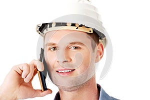 Contractor in hardhat talks on his cell phone.