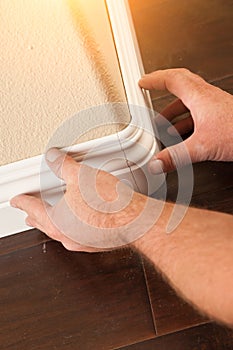 Contractor Installing New Baseboard with Bull Nose Corners and New Laminate Flooring