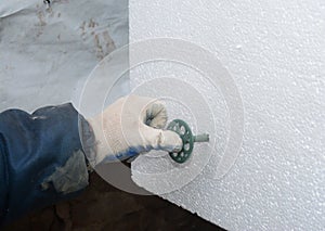 Contractor installing styrofoam rigid insulation board. How to attach rigid foam insulation