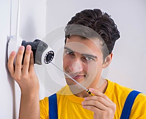 Contractor installing surveillance CCTV cameras in office