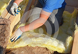 Contractor Insulating with Mineral Wool Attic Roof. Close up on insulation layers of mineral wool insulation, roof insulation