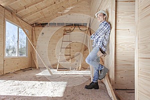 Contractor leaning against wooden wall