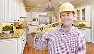 Contractor with Level Wearing Hard Hat Standing In Custom Kitchen