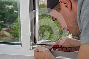 A contractor master adjusts and repair in house plastic windows.