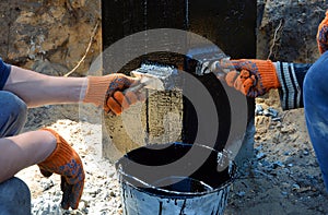 Contractor painting black coal tar or bitumen at concrete surface by the brush, a foundation Waterproofing for anti damp proofing