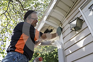 Contractor Popping Vinyl Siding Back In Place