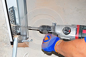 Contractor repair and install garage door with drilling machine. Replace a Broken Garage Door Spring.