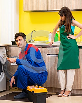 Contractor repairing washing machine at home