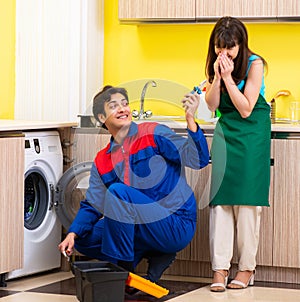 Contractor repairing washing machine at home