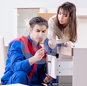 Contractor repairman assembling furniture under woman supervisio