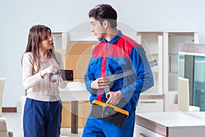 The contractor repairman assembling furniture under woman supervision