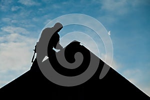 Contractor in Silhouette working on a Roof Top