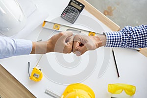 Contractor successfull teamwork. Engineer and architect partners giving fist bump after complete deal