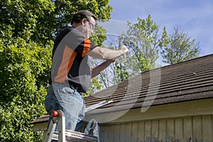 Contractor Taking Photos Of Hail Damaged Roof