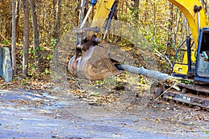 A contractor uproots trees with tractor in forest at preparation for construction of new building