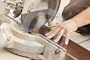 Contractor Using Circular Saw Cutting of New Laminate Flooring