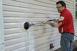 Contractor Using A High Pressure Brush To Remove Algae And Mold