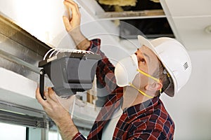 contractor using lamp to inspect roof area