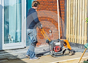 Contractor with a vibratory plate compactor