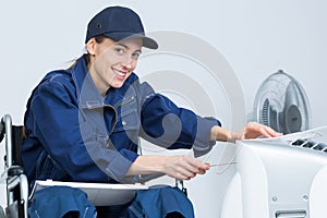 Contractor in wheelchair repairing electrical appliance