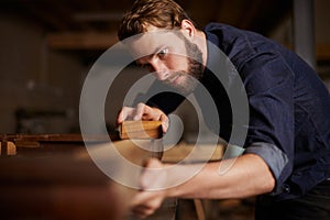 Contractor, wood sanding and man in workshop working on building construction and architecture. Home improvement