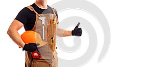 Contractor worker or carpenter in apron with tools and helmet holding thumbs up