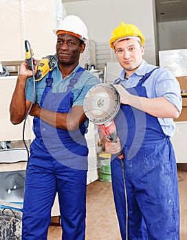 Contractors working with handheld power tools