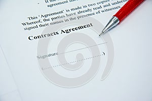 Contracts agreement sign on document paper with red pen photo