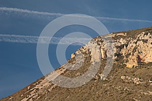 Contrails of airplanes and cliff in the Guara mountains.