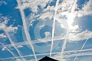 Contrails over Residential Area with Sun behind Clouds photo