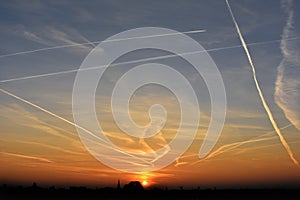 Contrails in the sky at sunset