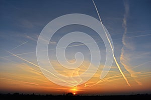 Contrails in the sky at sunset