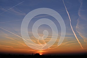 Contrails in the sky at sunset