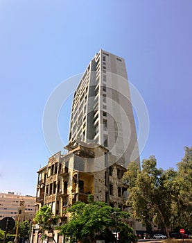 Contrast between a destructed beautiful house and a rectangle grey new building in Dampas street Beirut Lebanon