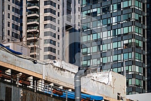 Contrasting architecture with an old building flanked by modern glass high-rises under blue sky