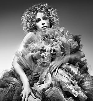 Contrasting black and white fashion portrait of beautiful young woman in a lush dress