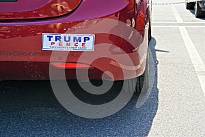 Contrasting bumper sticker Trump Pence on red car